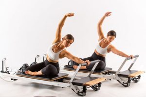 Two participants using a Reformer